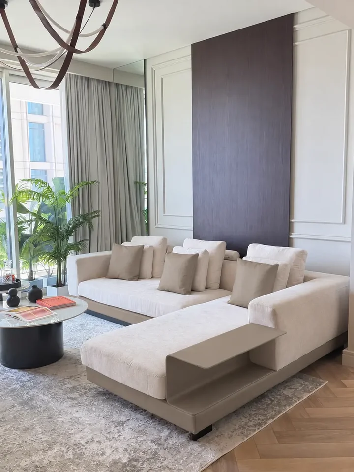 Atrakcyjna aranżacja nowoczesnego wnętrza z sofą narożną z półką, utrzymana w minimalistycznym stylu od Primavera Home.