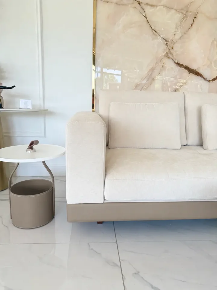 Sofa narożna z półką w ciepłym wnętrzu, tworząca przytulną atmosferę, prezentująca nowoczesny styl od Primavera Home.
