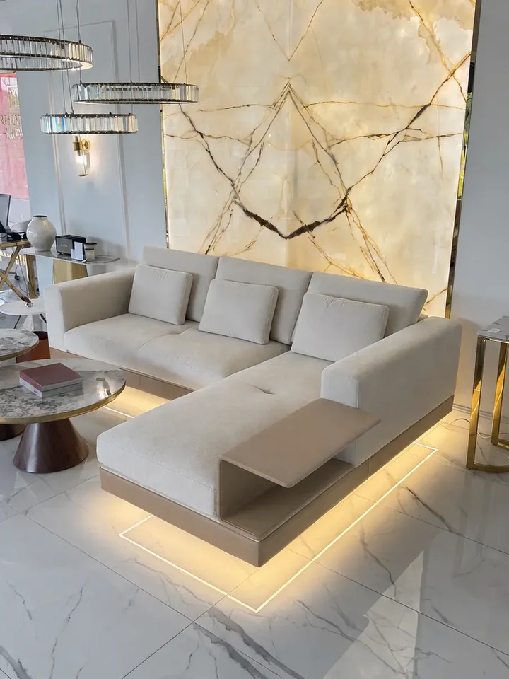 Ujęcie sofy narożnej z półką od dołu, które pokazuje eleganckie nogi i styl od Primavera Home.