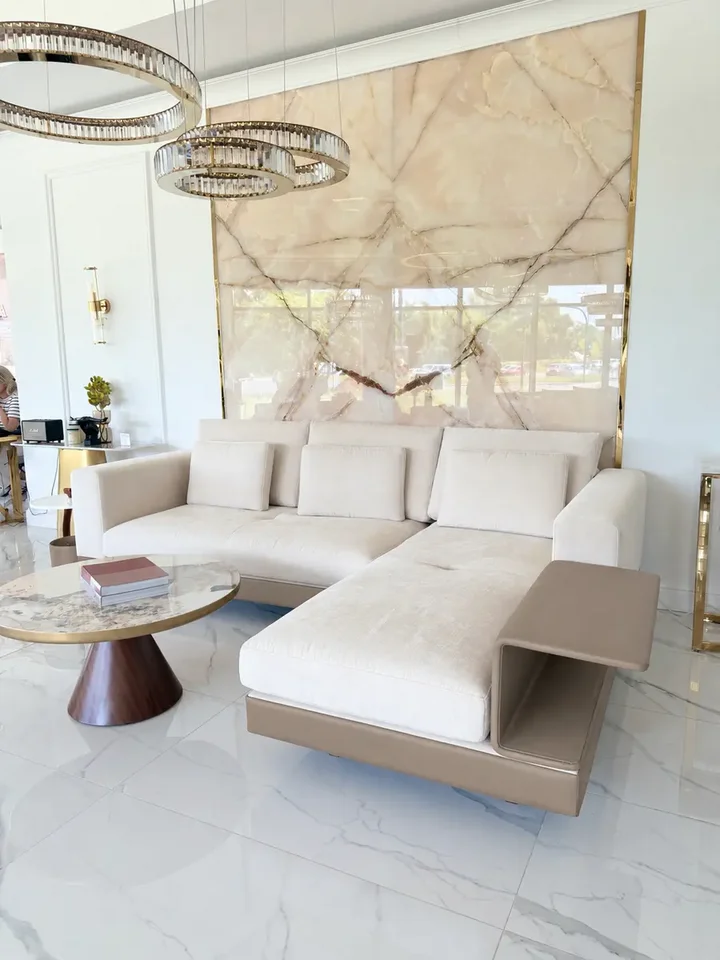Nowoczesna aranżacja sofy narożnej z półką, uwydatniająca jej nowoczesny design w przestrzeni salonu od Primavera Home.