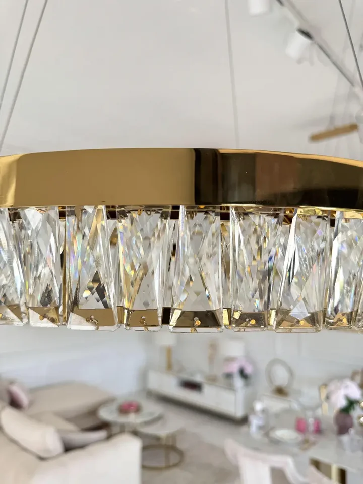 Złoty Żyrandol Kryształowy Bellini ukazany z boku, podkreślający jego elegancki design. Aranżacja nowoczesnego wnętrza od Primavera Home.