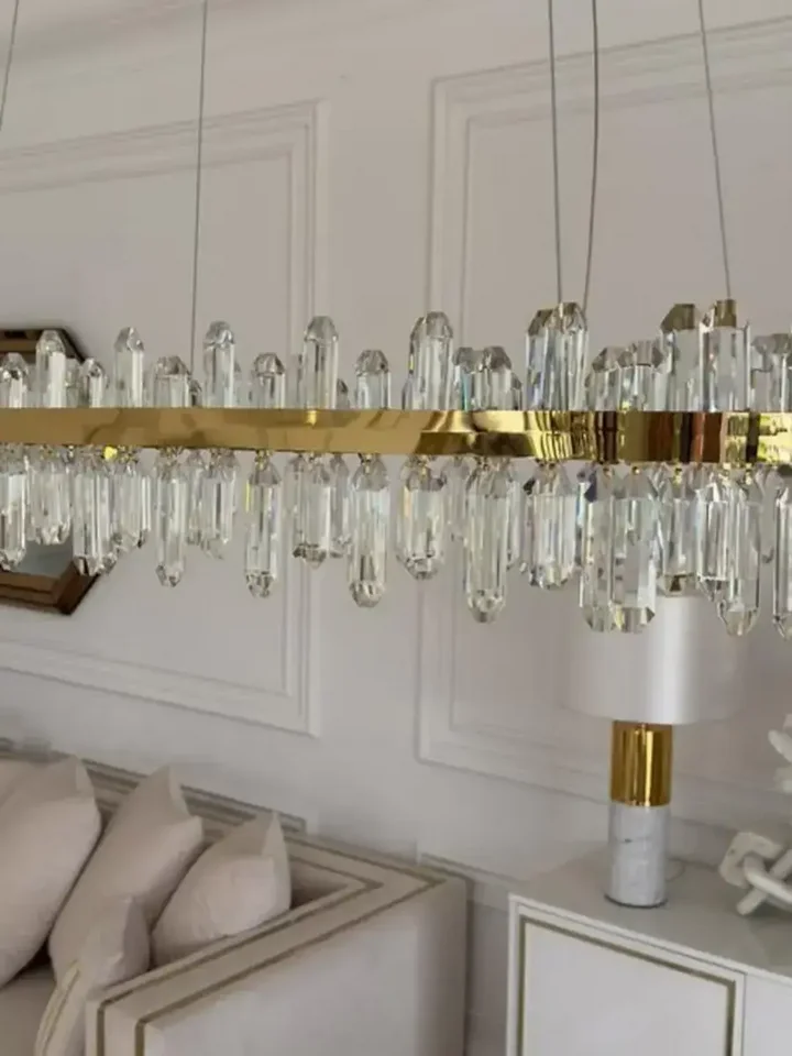 Iluminacja detalu Żyrandola BULGARI L 100cm Złoty, znakomicie oświetlającego przestrzeń. Ekspozycja w salonie od Primavera Home.