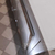 Komoda glamour lakierowana drewniana na stalowych nogach z wysokim połyskiem biała srebrna Lorenzo L Silver OUTLET